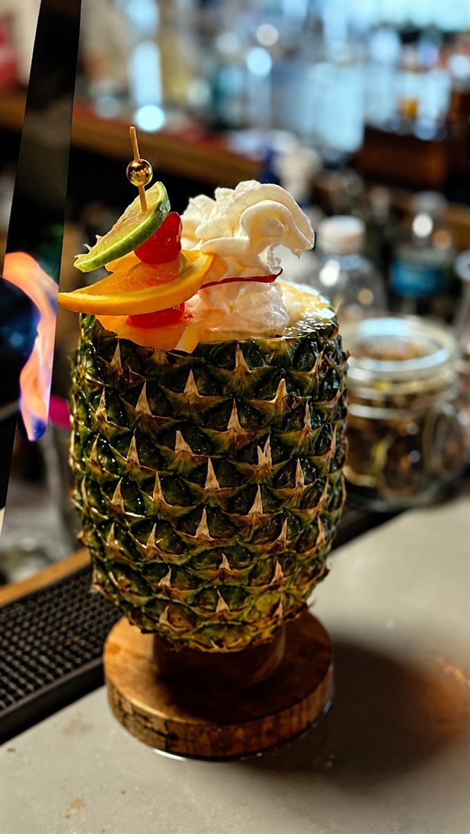 Cóctel servido en piña natural decorado con frutas