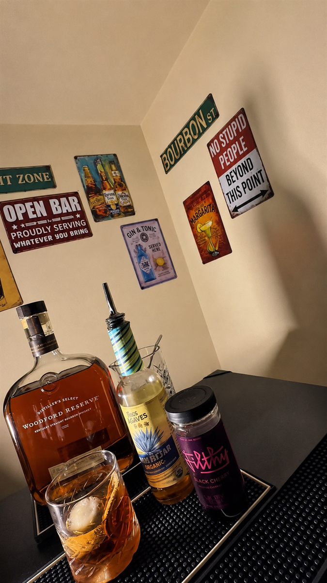 Estación de bar montada en una celebración en casa con whisky y cristalería